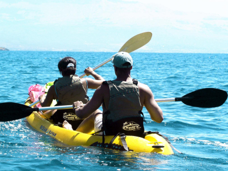 couple kayak along mauis rugged coastline