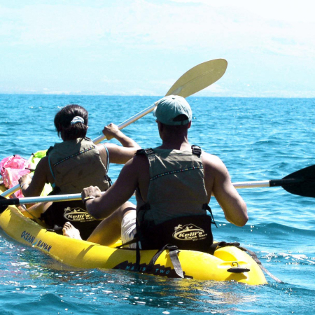 couple kayak along mauis rugged coastline