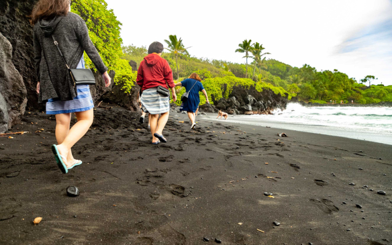black sand beach visitors walking waianapanapa road to hana maui opt